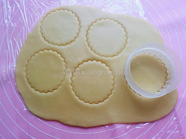 将切割下来的面团擀平，用模具压出圆片。