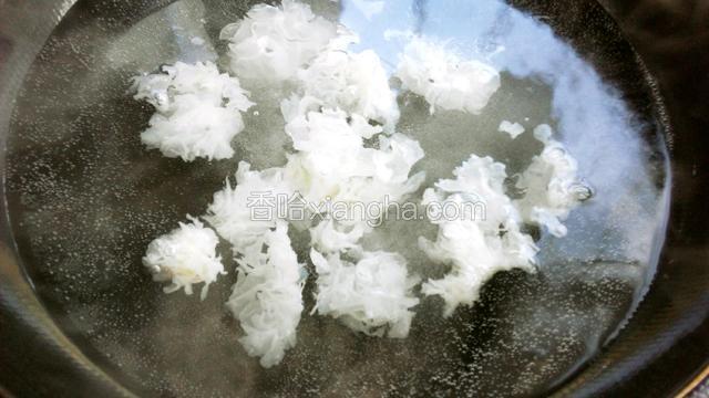锅里水烧开，放入银耳焯熟