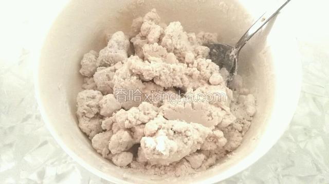 糯米粉里慢慢加入温水用勺子搅拌成大颗粒。