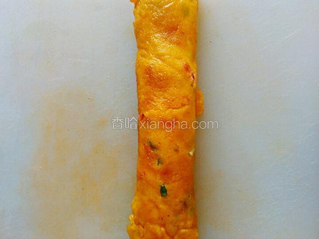 煎好饼放在菜板上卷起。
