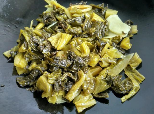 放入蒜头爆香，再炒酸菜。