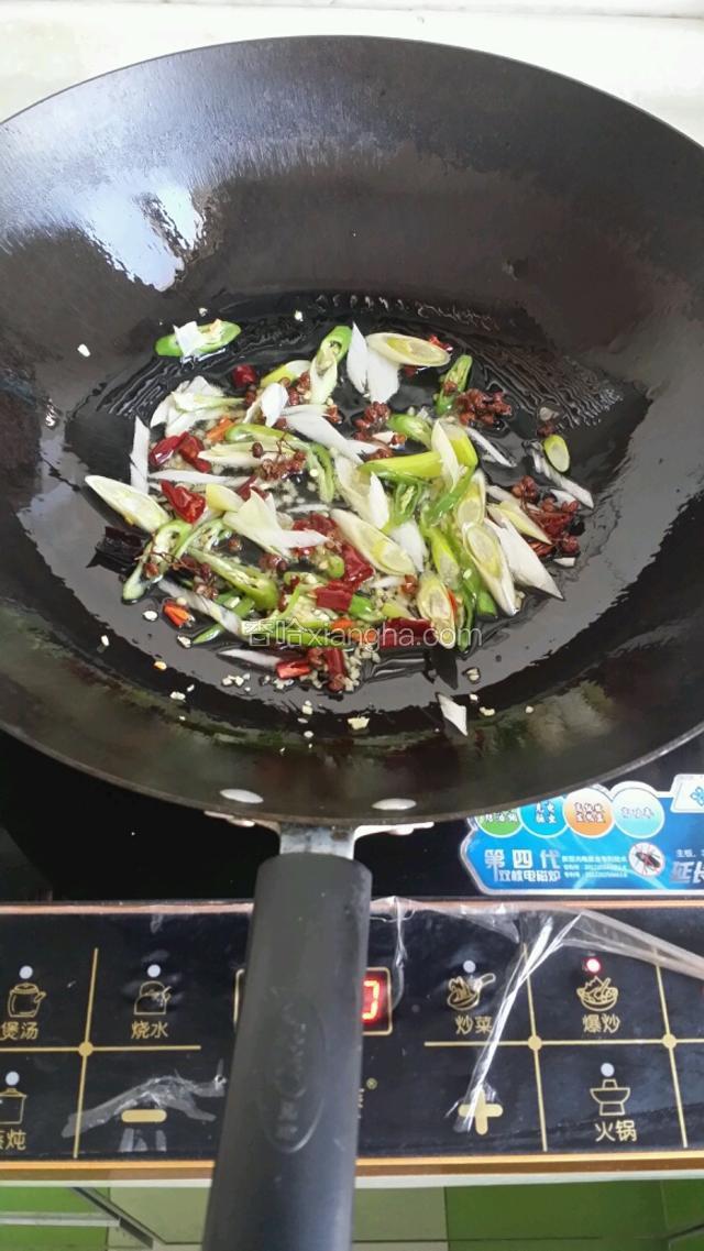 炒锅油热先放花椒粒，干红椒，青椒，葱姜炒出香味
