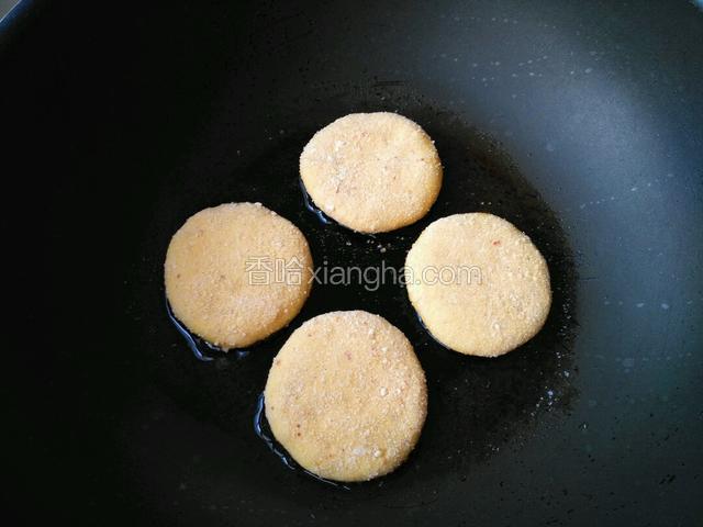 热油将红薯饼放锅中，小火煎至，