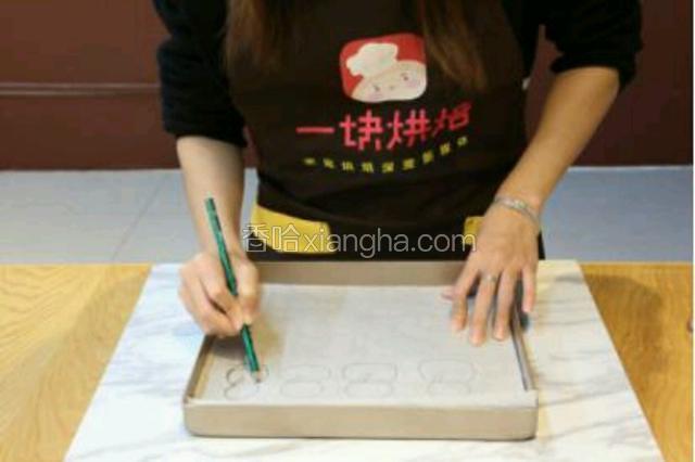 2.在烤盘上垫上油纸，用铅笔画出雪人，将油纸反过来铺垫以备用。