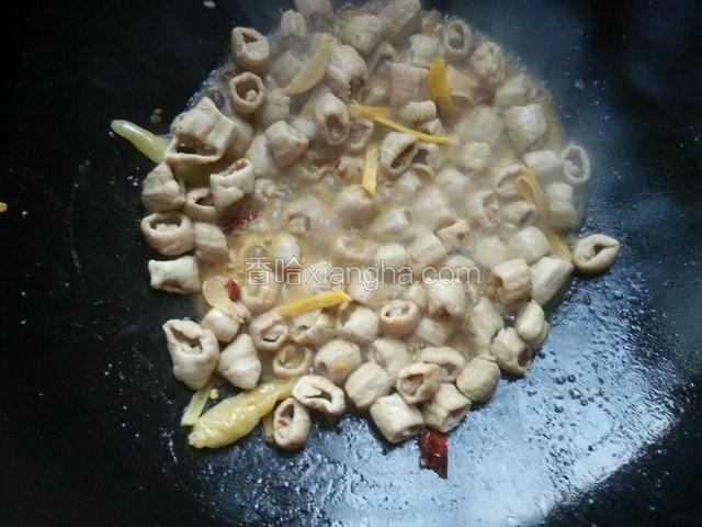 小肠炒至缩小时倒入适量料酒继续炒