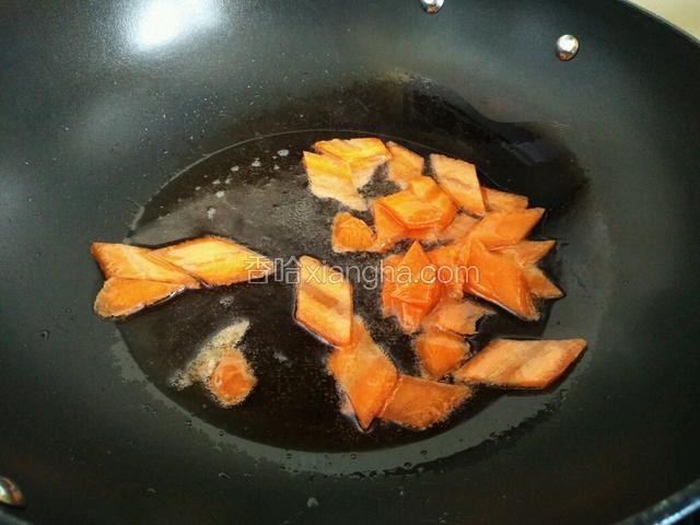 起油锅，将胡萝卜片炒数分钟。