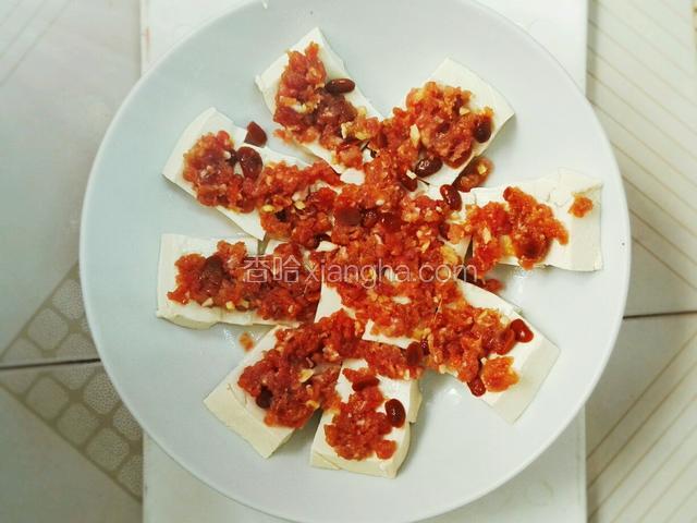 把腌制好的肉末，均匀的铺在豆腐上面