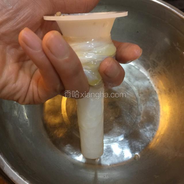 如图所示，用手指托住肠衣，防止滑脱