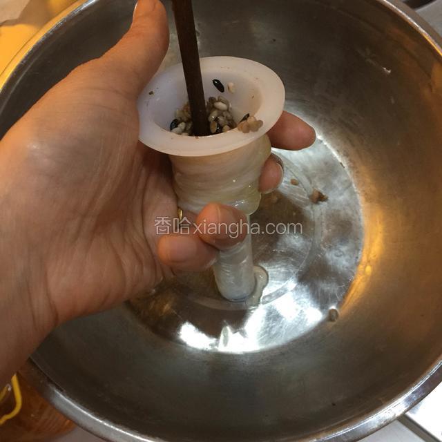 挖一勺放入灌肠器里，用筷子捅下去
