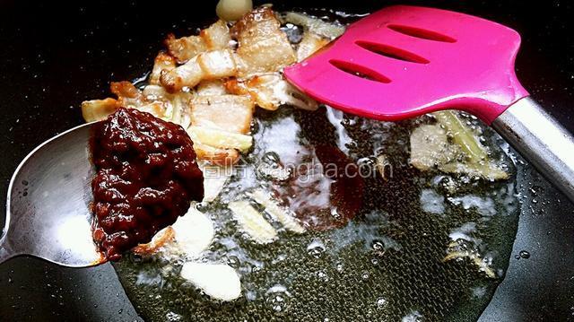 然后往锅内加豆瓣三克，把豆瓣煸出红油，煸出香味