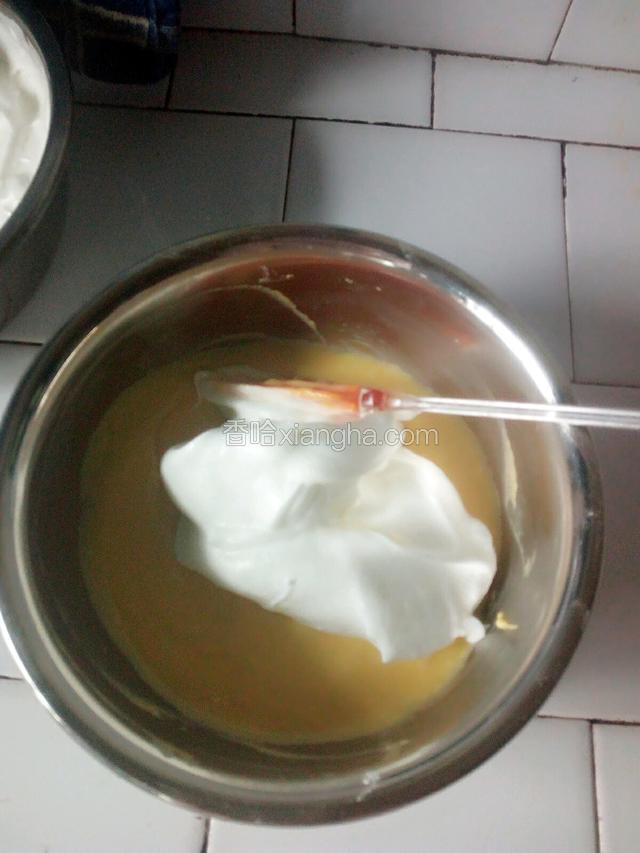 先舀三分之一打发好的到奶油倒进面糊拌匀,再加入三分之一拌匀,最后把拌好的面糊倒入剩下的奶油里翻拌均匀。