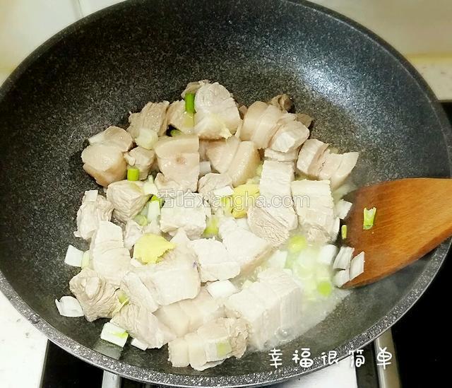 锅中加油加入生姜，葱段，倒入肉块煸炒。