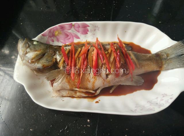 把红椒丝铺在鱼上，倒入一勺蒸鱼豉油。