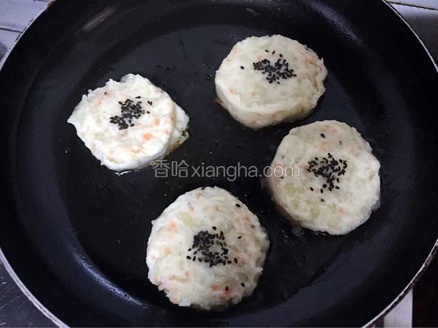平底锅倒入适量的油烧至七成热时放入土豆莲藕饼，小火煎至金黄色