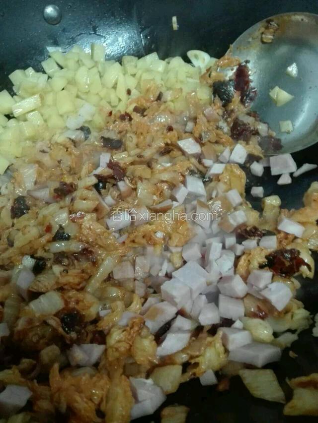 放酸菜粒、香肠粒中火和土豆粒炒匀。