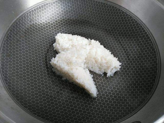 将蒸米下入锅中，约130克熟米饭。用铲子划开翻炒。