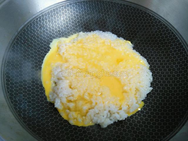 再将鸡蛋液均匀滴转圈淋在米上。之后翻炒均匀。