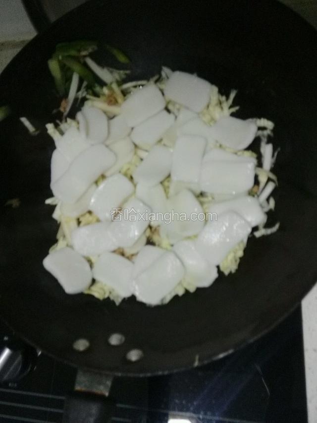 加入年糕片，铺匀至白菜丝上面，盖上锅盖用热气小火焖制10分钟；
