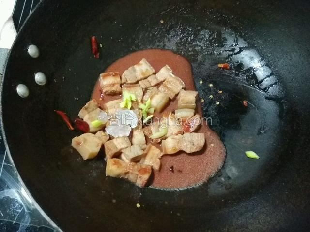 倒入南乳汁大火煮沸一分钟，加入冰糖，转中火煨制30分钟；