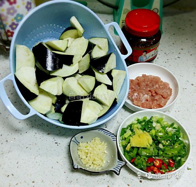 洗净的茄子切滚刀块，鲜肉剁成肉沫，葱切成葱花，蒜头切沫，小米椒，长青椒切成小粒，生姜拍碎。