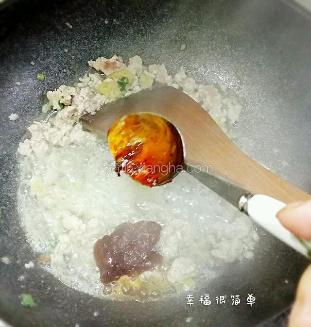 炸茄子的油倒出，留少量在锅中加入蒜沫，葱花，生姜，煸香后倒入肉沫炒至断生，喷入适量的料酒，加一勺豆瓣酱。