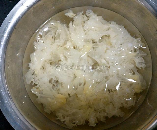 摘掉根部后，换水继续泡发3～4个小时，中间要换水。