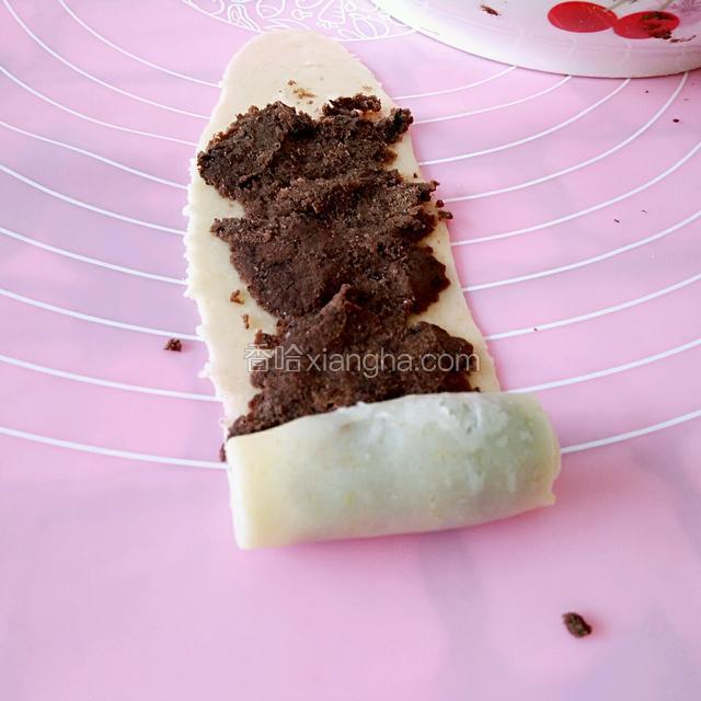 取出一个卷子竖着擀成牛舌状，然后抹上红豆沙。从下往上卷起