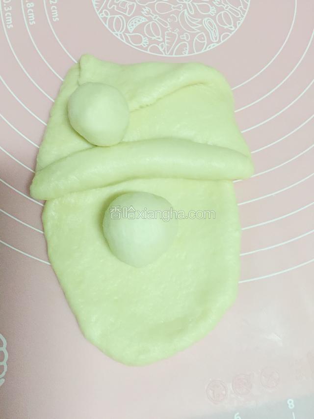 帽子放到脸的上面，32克的面团分成一大一小，大的做鼻子，小的做帽子上面的小球。