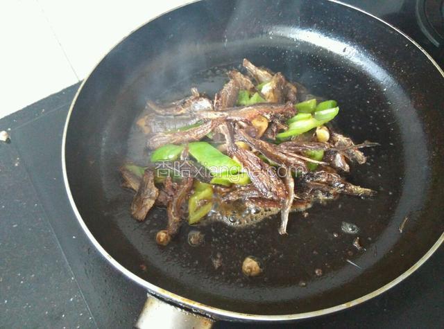 煸至青椒变软，加入少许生抽，倒入料酒。