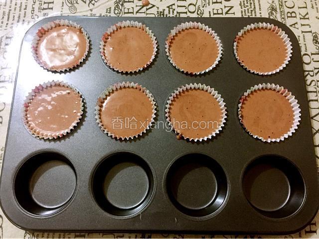 把纸杯放入蛋糕模具中，把蛋糕糊倒入纸杯中八九分满