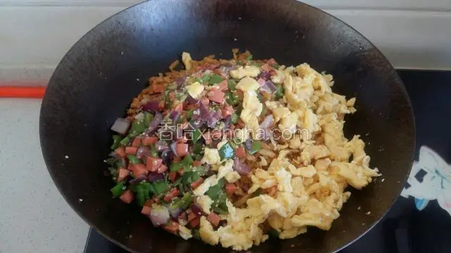 再次倒入鸡蛋碎和蔬菜火腿碎翻炒均匀。