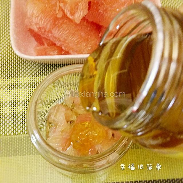 然后均匀地撒上一层柚子肉丝，尽量的将柚子肉撕碎，再倒上一层蜂蜜。