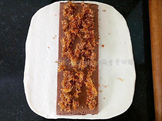放入一个蛋糕块在中间，铺上一些辣肉松。
肉松是随意的，你们可加可不加，如果要加的话就肉松40g和沙拉酱18g放容器里拌匀即可。
蛋糕夹心可以是原味蛋糕、可可蛋糕或抹茶蛋糕或其他任意自己喜欢的口味。
我这里用的可可戚风蛋糕，为了使整个菜谱更直观简洁，我把蛋糕的做法放最后面了，从步骤21开始。蛋糕可以提前一天制作，也可以在面团揉好后利用一发的时间来做，时间上大家根据自己的情况随意安排。