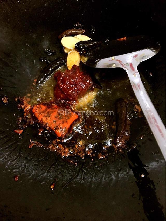 下入火锅底料、郫县豆瓣炒香至红油出来、
