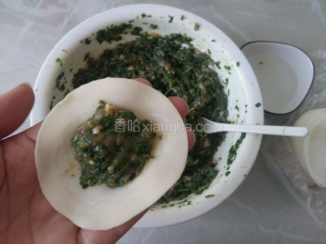 开始包饺子，另准备一小碗水，放适量馅饺子皮边缘涂一圈水更好包