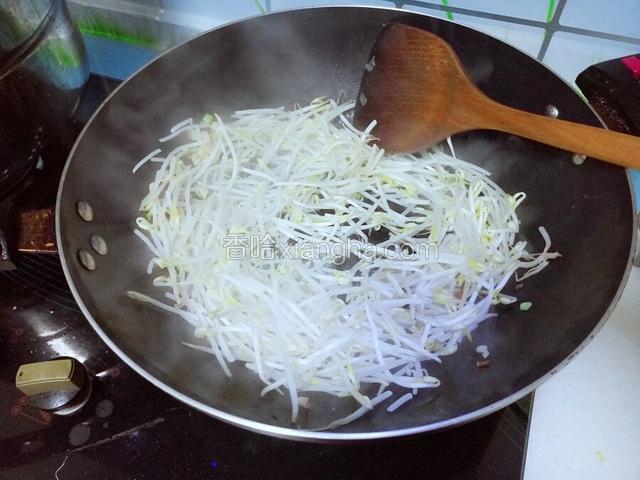 放入绿豆芽翻炒，炒软后加入盐，调料和醋翻炒，最后加入葱叶和鸡精，翻炒，出锅。