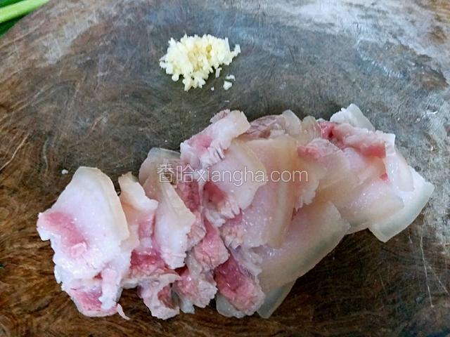 在案板上把姜剁成碎末，五花肉切厚度为0.5厘米的片。