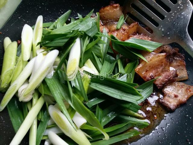 五花肉炒制上色后，把切好的香蒜下锅，调中火，把五花肉和香蒜同炒制三分钟。