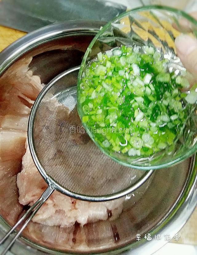 拍打好的鱼肉糜放入干净的容器中。借助漏勺，泌入葱姜汁。