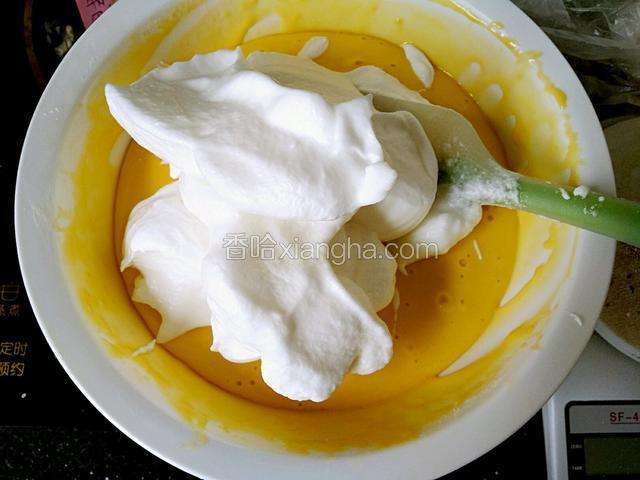 取1/3的蛋白放入蛋黄糊中，用铲子翻拌。手法要从下往上炒菜似的翻拌不可画圈搅拌。