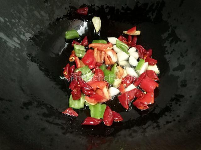 锅里放入适量的油下入干辣椒，青红椒，姜，蒜炒出香味。