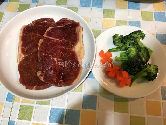 牛排解冻后拆包放入盘中，胡萝卜切成小花片、西兰花切成小块