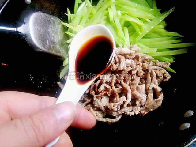 大火下莴笋丝，翻炒几下，迅速下肉丝放少许生抽上色。