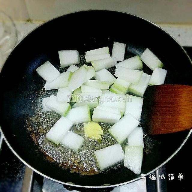 锅中放入适量清油，下生姜和冬瓜煸炒一分钟。
