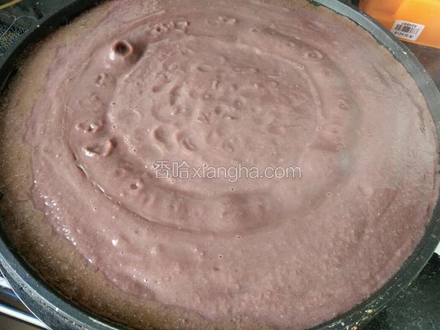 用电饼铛放入玉米油烧热，把红豆泥倒进电饼档中开始炒制。