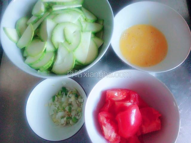 准备食材：西葫芦从中间划开再切薄片，鸡蛋打散，西红柿切块，葱切成葱花