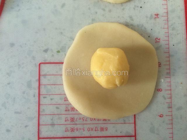 取一个黄油皮，用水油皮包起来，收口位置收紧搓圆