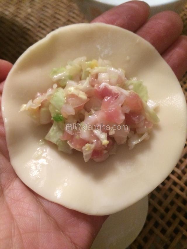 取一张饺子皮，在饺子边缘涂上水