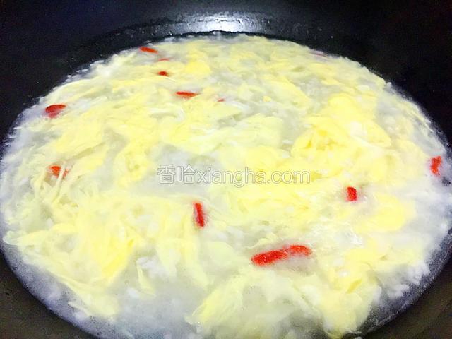 放入枸杞和倒入搅打均匀的鸡蛋液一边倒蛋液一边用勺子推动汤汁至鸡蛋液成蛋花即可熄火。