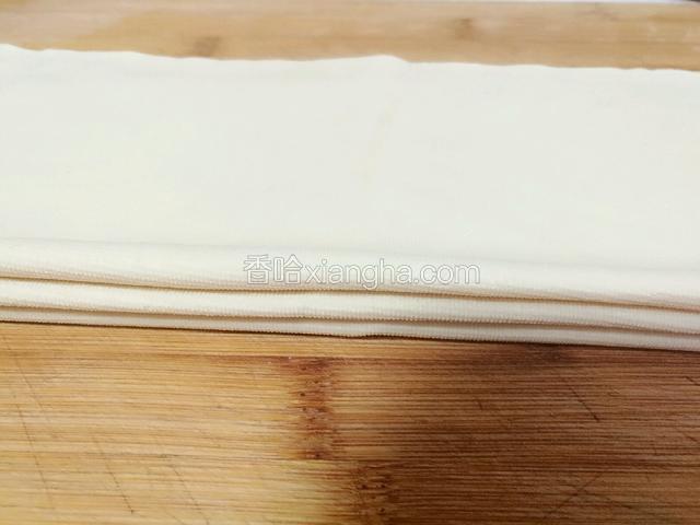 取三份豆腐皮，每份都对折，然后叠放整齐(这样卷起的豆皮卷更容易入味)。